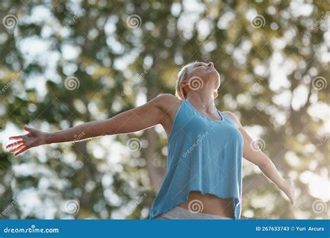 Embrace Life With Open Arms A Mature And Fit Woman Standing Outside In Nature With Her Arms