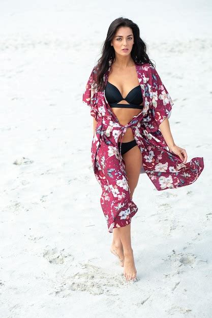 Eine Frau In Einem Schwarzen Bikini Und Einem Schwarzen Bikini Geht Am Strand Spazieren