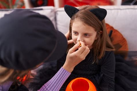 Adorable Fille Blonde Assise Sur Un Canapé Se Maquillant Pour Halloween à La Maison Photo Gratuite