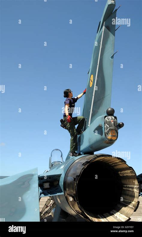 A technician performs post flight maintenance on a JASDF F-2 fighter ...