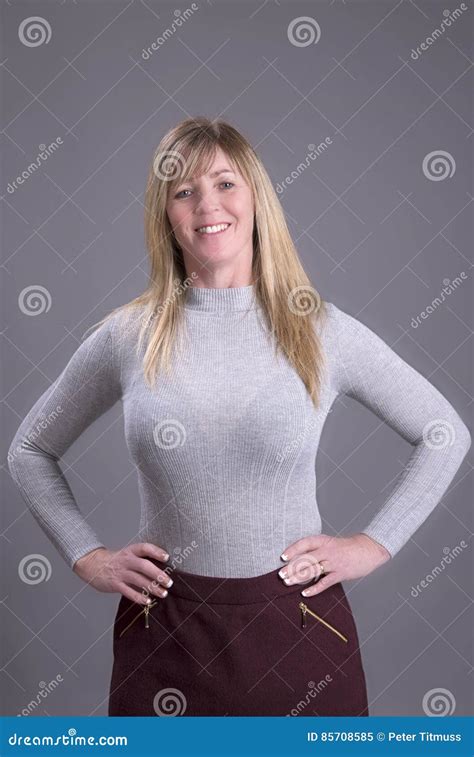 Femme Avec Des Mains Sur La Taille Portant Un Pullover Serré Image