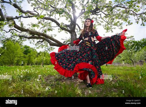 Young Woman In Traditional Gypsy Dress Performing A Dance In An Apple