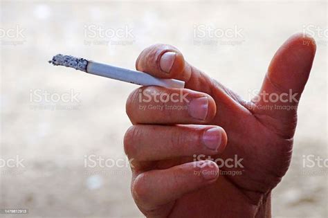 A Human Hand Holding A Cigarette Cigarettes And Cancer Cigarettes Are