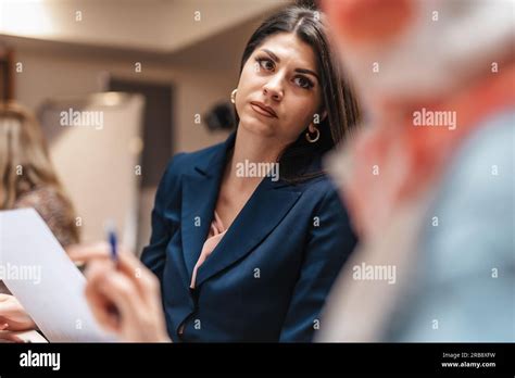 Female Brunette Employee Listening To Her Muslim Female Colleague A Team Leader Explaining