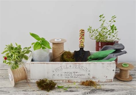 An Old Wooden Box Filled With Plants And Spools Of Thread On Top Of A Table