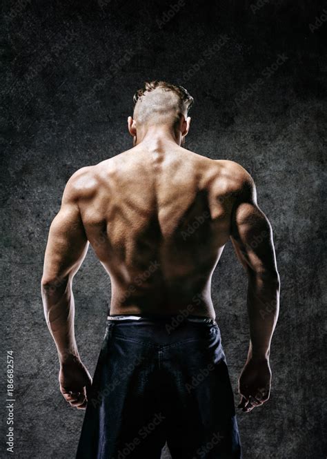 Back View Naked Torso Of Muscular Man On Dark Background Strength And Motivation Stock Photo