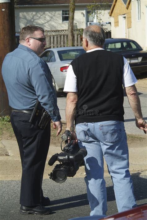 Poliziotto Che Parla Con Un Cameraman Televisivo Mentre Fotografia