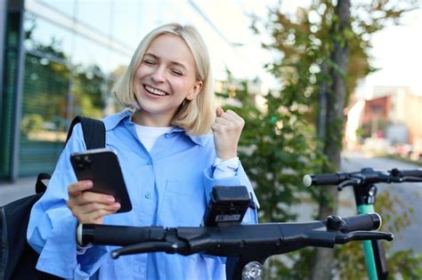 Portrait d une étudiante blonde souriante utilisant une application de smartphone pour numériser