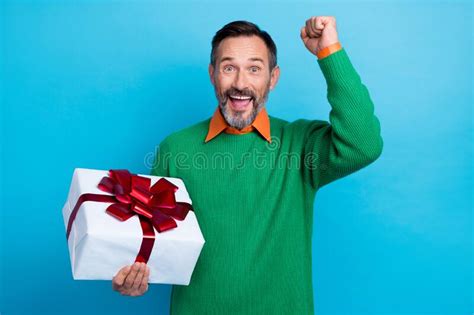 Photo Portrait Of Mature Handsome Man Raise Fist Excited Hold Birthday Giftbox Wear Trendy Green