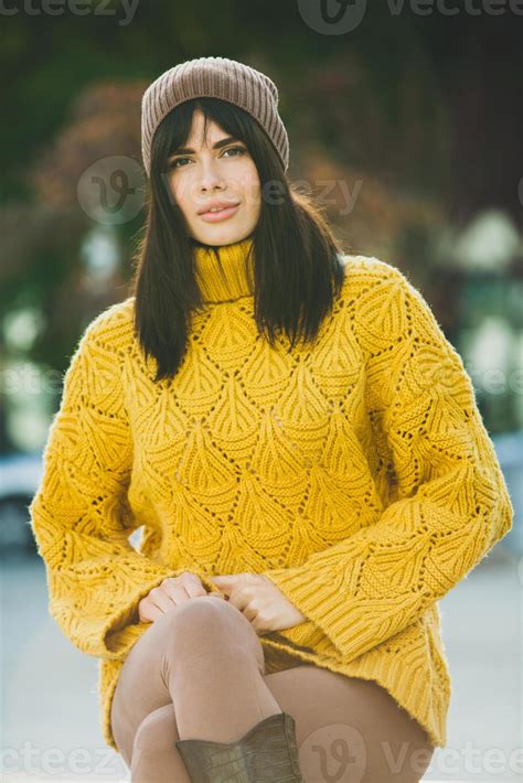 Beautiful European Brunette Dressed In A Yellow Woolen Sweater And Hat Outside The Beautiful