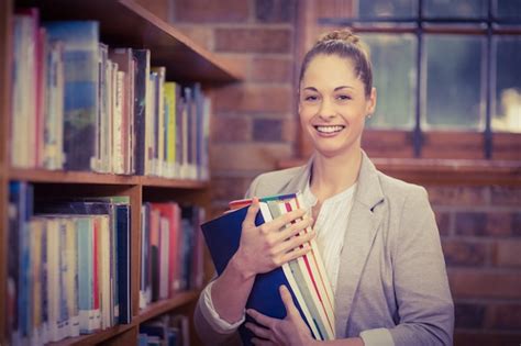 Premium Photo Blonde Teacher Holding Books In The Library