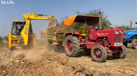 Jcb Dx Backhoe Loader Machine Loading Mud In Mahindra Di Tractor