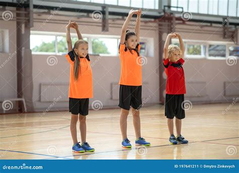 Three Kids Doing Stretching On Pe Lesson Stock Image Image Of