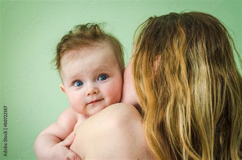 Naked Girl Baby On The Shoulder Of Mothers On A Green Background Stock Photo Adobe Stock