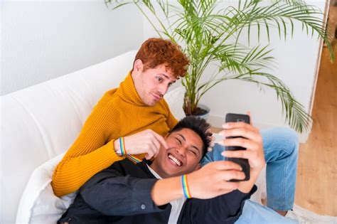 Lindo casal gay sendo romântico dentro de casa no sofá casal gay tomando selfie conceito lgbt