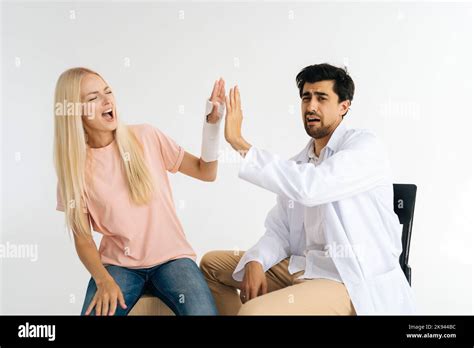 Funny Male Doctor Give High Five To Cheerful Female Patient With Broken
