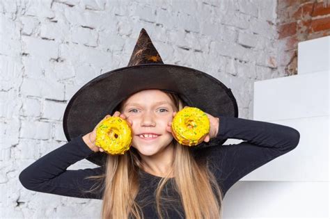 Enfants D halloween Une Petite Fille Blonde Souriante Dans Un Costume De Sorcière Tenant Des