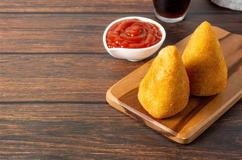 Dos Deliciosas Coxinhas En Una Tabla De Cortar De Madera Sobre La Mesa