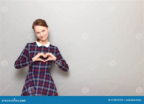 Portrait Of Happy Girl Making Heart Gesture With Hands Over Chest Stock