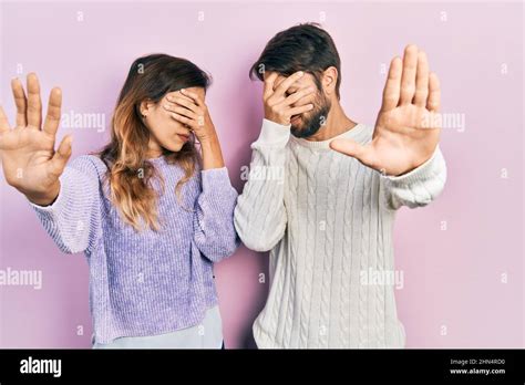 Young Hispanic Couple Wearing Casual Clothes Covering Eyes With Hands