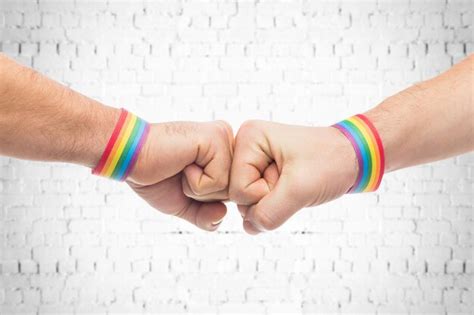 Manos con pulseras de orgullo gay hacen golpe de puño Foto Premium