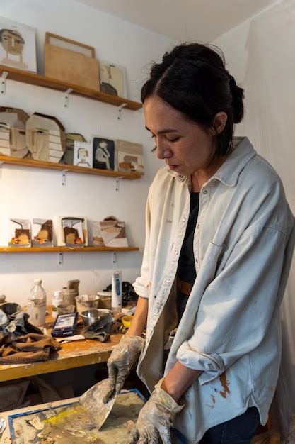 Jovem latina em seu próprio estúdio de pintura cria pinturas diferentes técnicas artísticas