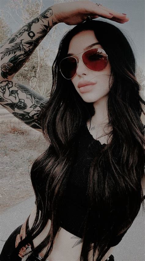 A Woman With Long Hair Wearing Sunglasses And Holding Her Hand On Top