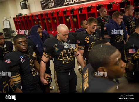 Army Black Knights football players hold hands as they listen to Army ...