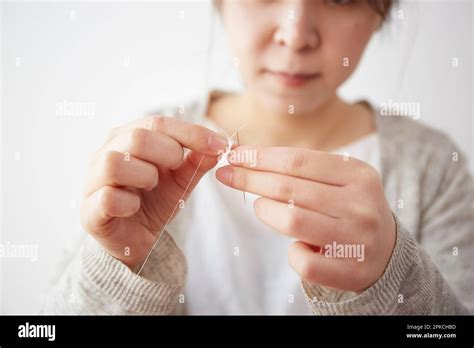 Woman Threading A Needle Stock Photo Alamy