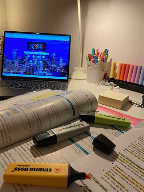 An Open Laptop Computer Sitting On Top Of A Desk Next To Some Pens And