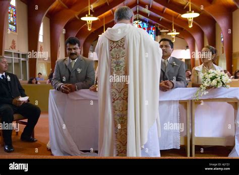 Catholic Priest administers wedding vows to two Latino American couples ...