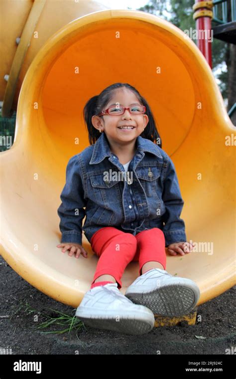 jährige Brünette Latina spielt auf der Rutsche im Park und lebt in Armut und glücklich