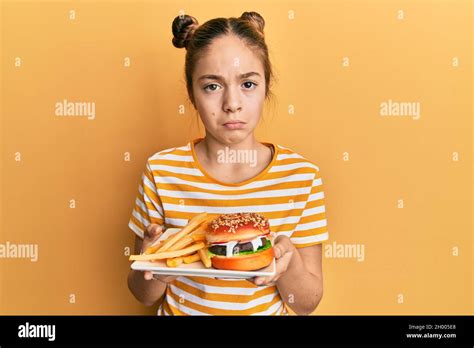 Belle Petite Fille Brunette Mangeant Un Savoureux Hamburger Classique Avec Des Frites D Prim Es