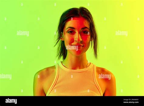 Image With Charming Brunette Girl Wearing White Top Smiling Over Pink Studio Background In Neon