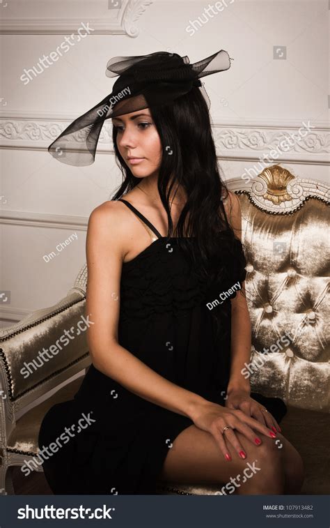 Attractive Brunette Sitting On Couch Boudoir Stock Photo
