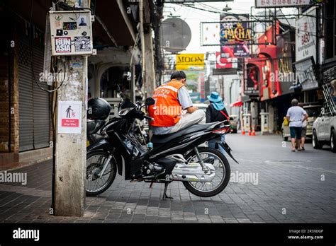 A Thai Motorcycle Rider Who Works As A Taxi Service Takes A Break Sat