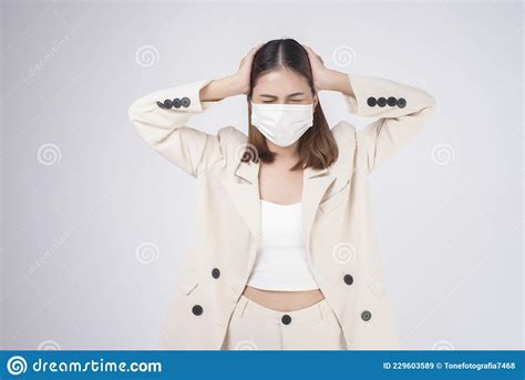 Portrait Of Young Businesswoman Wearing A Surgical Mask Over White