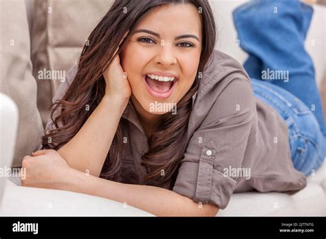 Portrait d une belle jeune femme hispanique de Latina avec des dents parfaites sur un canapé à