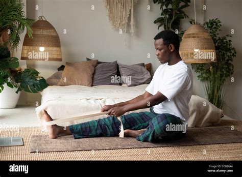 Young African Man Sitting In Janushirshasana Seated Forward Bend