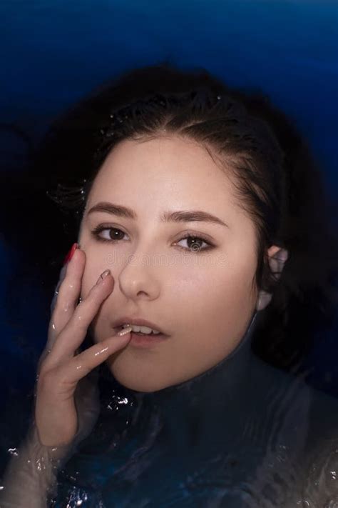Portrait Of Attractive Brunette Woman Topless In Blue Liquid In Bathtub With Colored Water