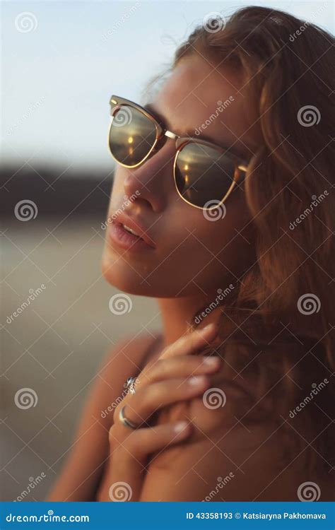 Portrait Of A Young Beautiful Woman With Long Curly Hair In Sunglasses