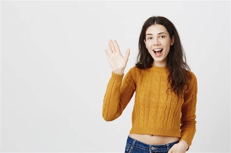 Free Photo Friendly Brunette Girl Saying Hi Waving Hand In Hello