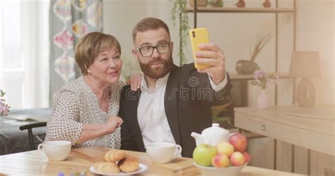 Front View Of Happy Son And His Mature Good Looking Mother Having Fun And Taking Selfie Man In
