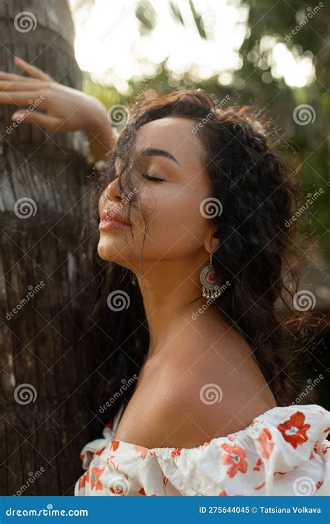 Carefree Relaxed Brunette Woman Leaning On Palm Tree Trunk With Close Eyes Breathe Deeply In