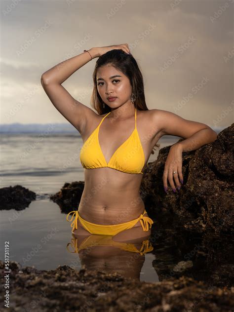 Foto De Sexy Asian Woman Spending Sunset On The Beach Attractive Woman Wearing Yellow Bikini