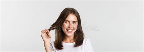 Close Up Of Flirty Attractive Brunette Girl Playing With Hair Strand Smiling And Looking