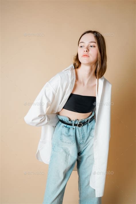 Fashion Model Beautiful Nude Girl In White Shirt Looking At The Camera Isolated On Beige