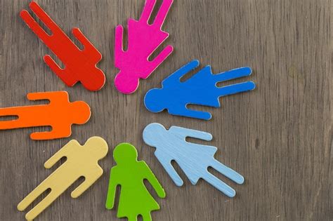 Figuras masculinas e femininas do orgulho gay do arco íris em fundo de madeira Foto Premium