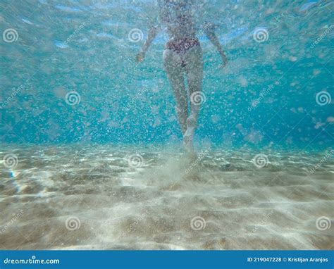 Vista Submarina Trasera De Mujer En Bikini Caminando Sobre Arena Bajo El Mar Foto De Archivo