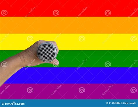 Mano Sosteniendo Un Micrófono Con Fondo De Bandera De Orgullo Gay Foto de archivo Imagen de
